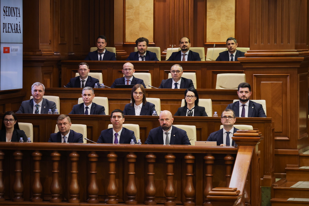 Prime Minister designate Vasile Tofan, right, on the bottom row, sits with his government team before the parliament's confidence vote in Chisinau, Moldova, Tuesday, July 21, 2026. (AP Photo/Aurel Obreja)