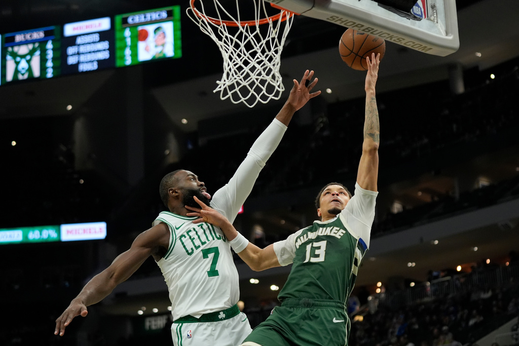 Milwaukee Bucks' Ryan Rollins (13) shoots against Boston Celtics' Jaylen Brown (7) during the first half of an NBA basketball game Thursday, Dec. 11, 2025, in Milwaukee. (AP Photo/Aaron Gash)
