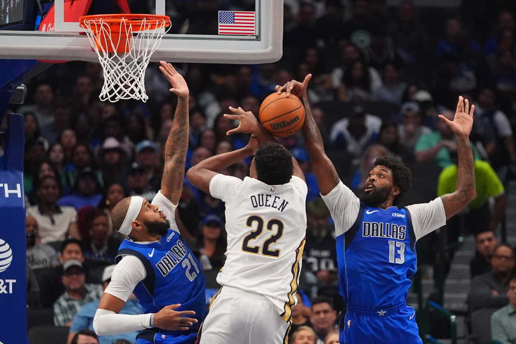 New Orleans Pelicans center Derik Queen (22) tries to get past Dallas Mavericks defenders Naji Marshall (13) and Daniel Gafford (21) during the first half of an NBA basketball game in Dallas, Wednesday, Nov. 5, 2025. (AP Photo/LM Otero)