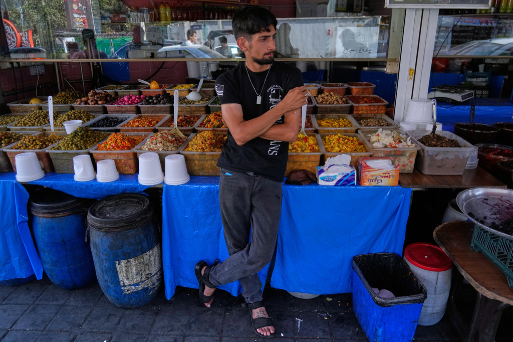 A vendor waits for customer outside his shop in Tehran, Iran, Monday, Aug. 10, 2026. (AP Photo/Vahid Salemi)