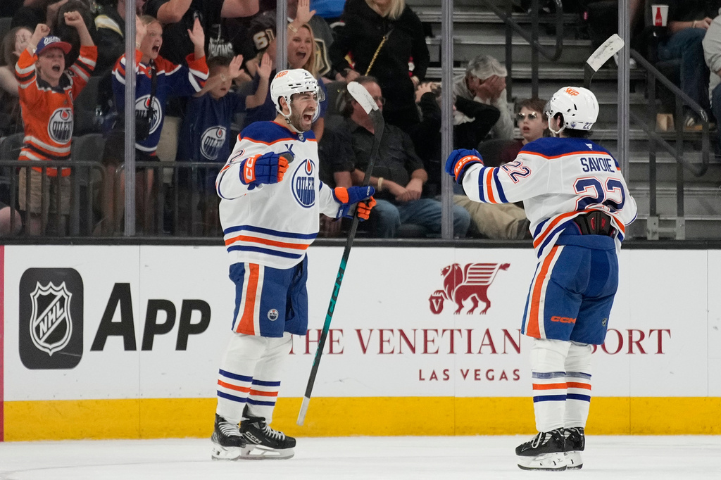 Edmonton Oilers defenseman Evan Bouchard, left, celebrates after scoring against the Vegas Golden Knights during overtime of an NHL hockey game Thursday, March 26, 2026, in Las Vegas. (AP Photo/John Locher)