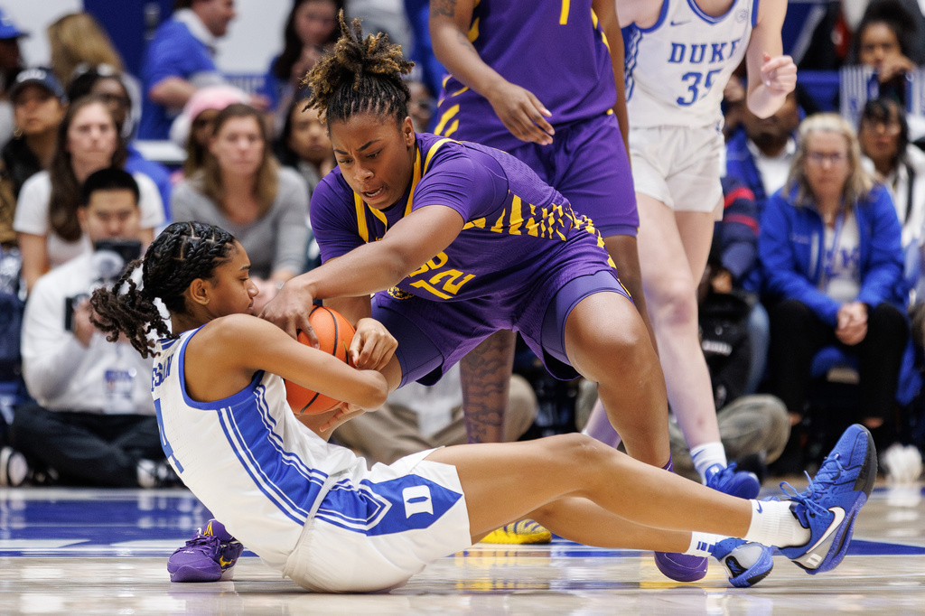 LSU's Mikaylah Williams (12) and Duke's Riley Nelson (4) battle for a loose ball during the second half of an NCAA college basketball game in Durham, N.C., Thursday, Dec. 4, 2025. (AP Photo/Ben McKeown)