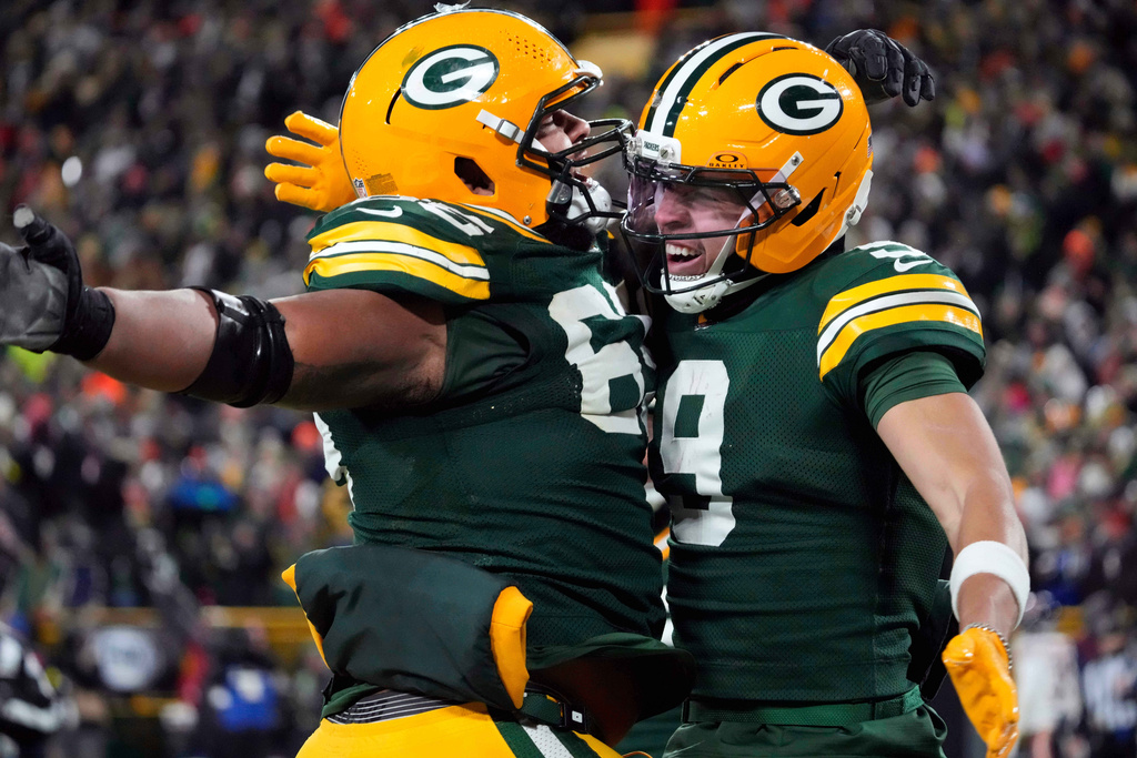 Green Bay Packers wide receiver Christian Watson (9) celebrates with guard Aaron Banks (65) after scoring a touchdown against the Chicago Bears during the second half of an NFL football game Sunday, Dec. 7, 2025, in Green Bay, Wis. (AP Photo/Morry Gash)