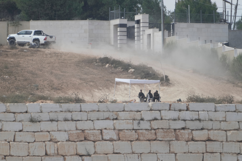 Israeli soldiers sit under a tent in front of the house of Ohio-based Palestinian-American landlord Loui Ridi, that is besieged by Israeli settlers for over a week, in the occupied West Bank village of Qusra, south of Nablus, Tuesday, Aug. 18, 2026. (AP Photo/Majdi Mohammed)