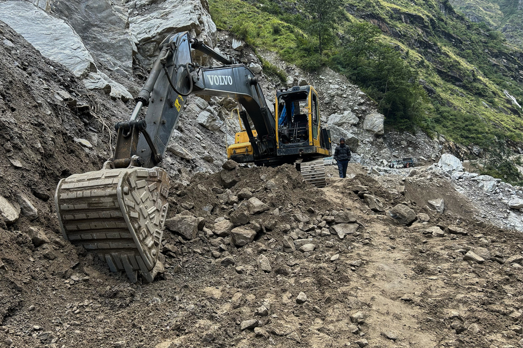 An earthmover clears a unpaved mountain road of debris near Laspa viallge, in the northern Indian Himalayan state of Uttarakhand, on Oct. 4, 2025. (AP Photo/Satish Sharma)