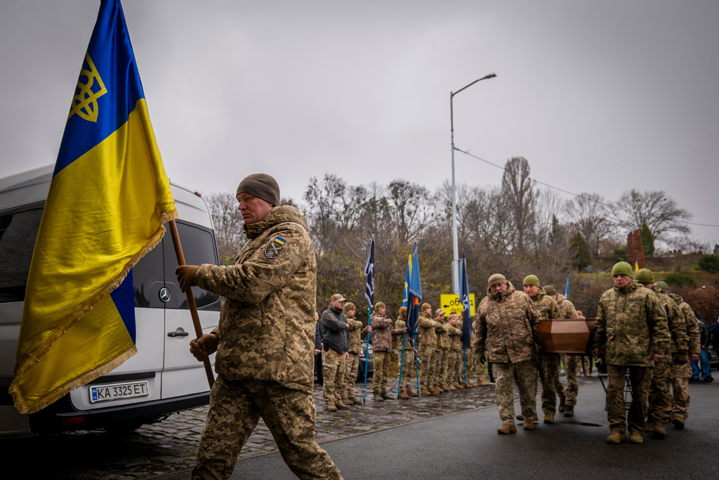 Servicemen carry the coffin of volunteer soldier Yukhym Agafontsev, 22, killed in a battle with the Russian troops, during a farewell ceremony in Kyiv, Ukraine, Tuesday, Dec. 2, 2025. (AP Photo/Dan Bashakov)