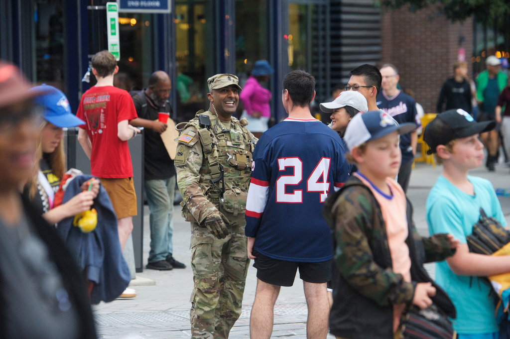 FILE - People talk with a member of the District of Columbia National Guard as they patrol the area outside Nationals Park in Washington, Aug. 19, 2025. (AP Photo/Rod Lamkey, Jr.)