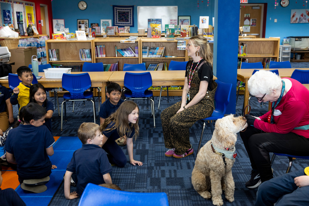 School social worker Nicole Herje, center, therapy dog Sage and Sage's owner Linda Buchs-Hammonds sit in on a class in the library at Valley View Elementary School on April 29, 2026, in Columbia Heights, Minn. (Ellen Schmidt/MinnPost via AP)