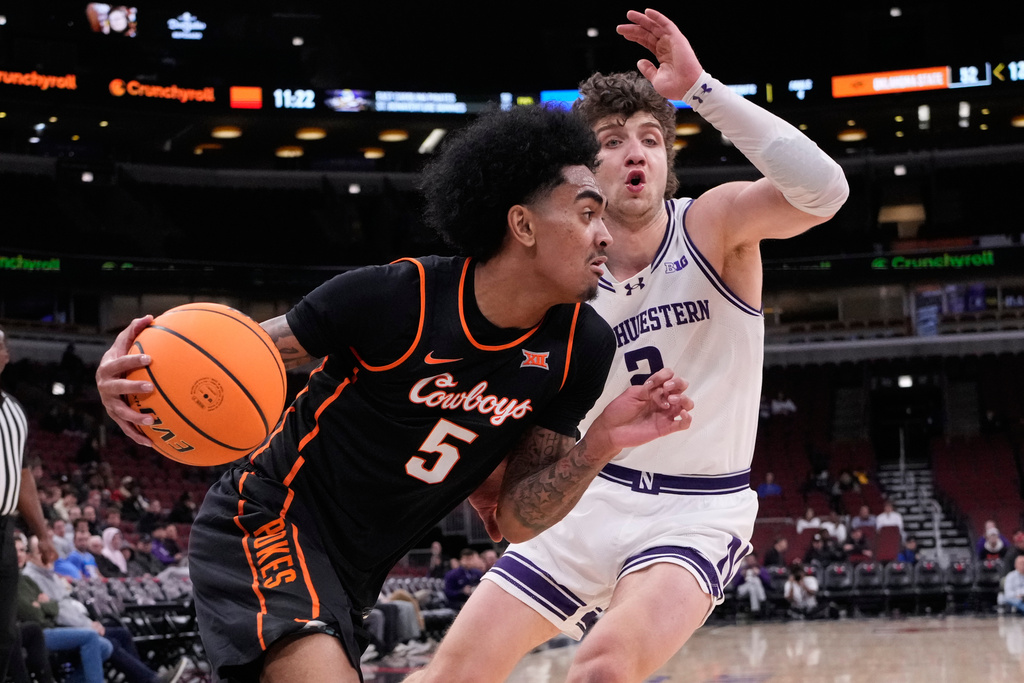 Oklahoma State guard Vyctorius Miller, left, drives as Northwestern forward Nick Martinelli guards during the second half of an NCAA college basketball game in the CBS Sports Thanksgiving Classic tournament Thursday, Nov. 27, 2025, in Chicago. (AP Photo/Nam Y. Huh)