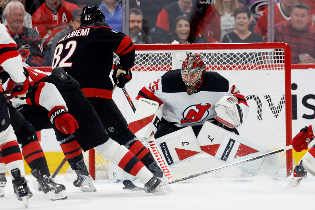 New Jersey Devils goaltender Jacob Markstrom (25) blocks a shot by Carolina Hurricanes' Jesperi Kotkaniemi (82) during the first period of an NHL hockey game in Raleigh, N.C., Thursday, Oct. 9, 2025. (AP Photo/Karl DeBlaker)