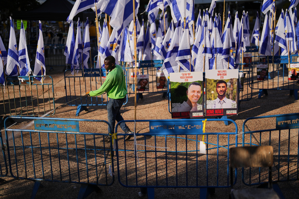 A worker cleans the ground at the plaza known as hostages square, in Tel Aviv, Israel, Tuesday, Oct. 14, 2025. (AP Photo/Francisco Seco)