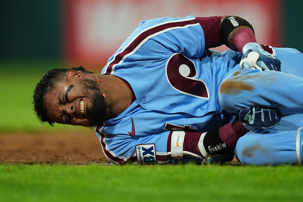 Philadelphia Phillies' Luis Arraez rects to an injury after being thrown out at first base during the sixth inning of a baseball game against the Milwaukee Brewers, Thursday, Sept. 24, 2026, in Philadelphia. (AP Photo/Matt Rourke)