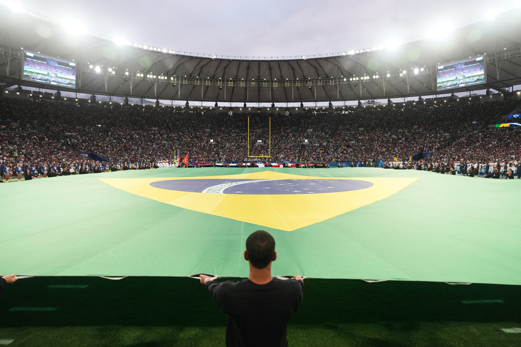Crews hold a Brazilian flag on the field before an NFL football game between the Dallas Cowboys and the Baltimore Ravens in Rio de Janeiro, Sunday, Sept. 27, 2026. (AP Photo/Fernando Llano)