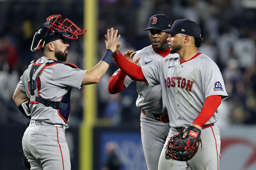 Boston Red Sox first baseman Willson Contreras, front right, high-fives catcher Connor Wong, left, in front of pitcher Aroldis Chapman, back right, after defeating the New York Yankees in a baseball game Friday, June 5, 2026, in New York. (AP Photo/Adam Hunger)