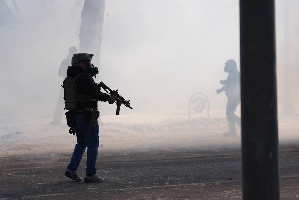 Federal immigration officers deploy tear gas after a shooting in Minneapolis, on Saturday, Jan. 24, 2026. (AP Photo/Abbie Parr)