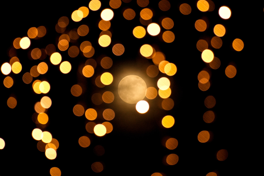 A supermoon, seen through decoration lights, rises up in the sky, in Istanbul, Turkey, Thursday, Dec. 4, 2025. (AP Photo/Emrah Gurel)