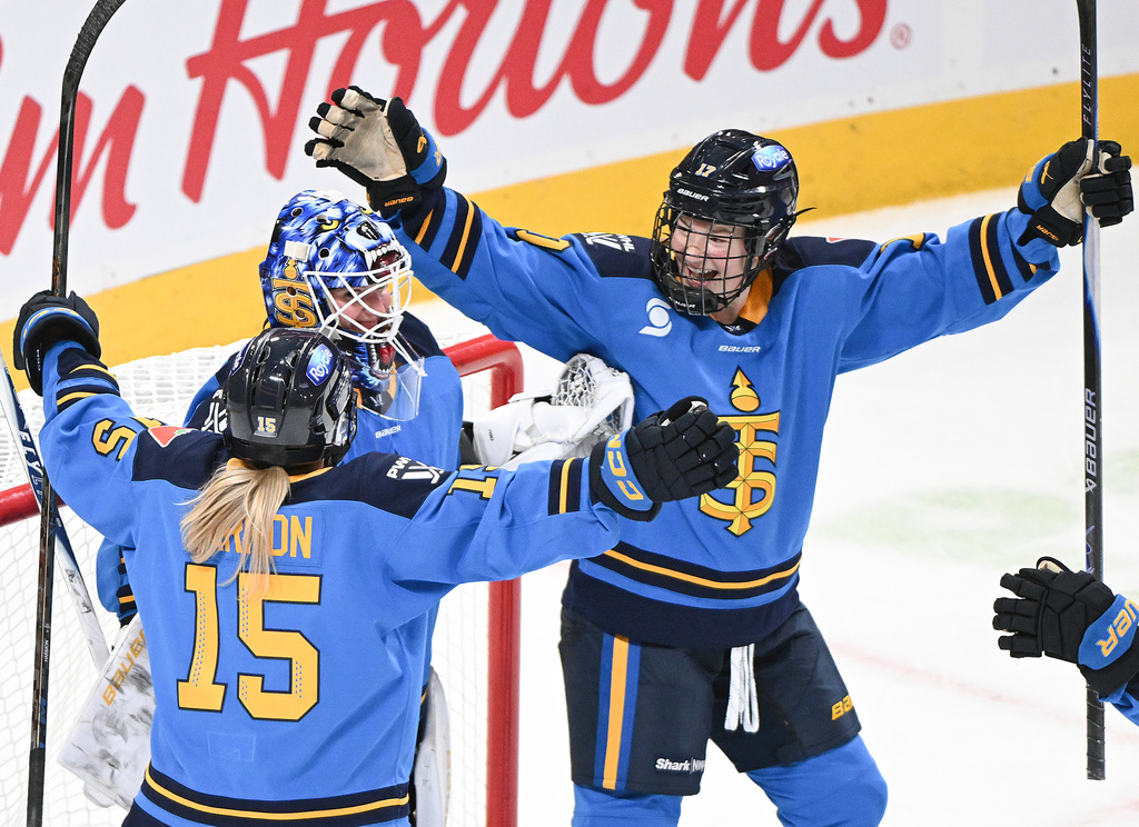 Toronto Sceptres goaltender Elaine Chuli, center, celebrates with teammates Savannah Harmon (15) and Ella Shelton, right, after defeating the Montreal Victoire in a PWHL hockey game in Montreal, Saturday, Dec. 27, 2025. (Graham Hughes/The Canadian Press via AP)