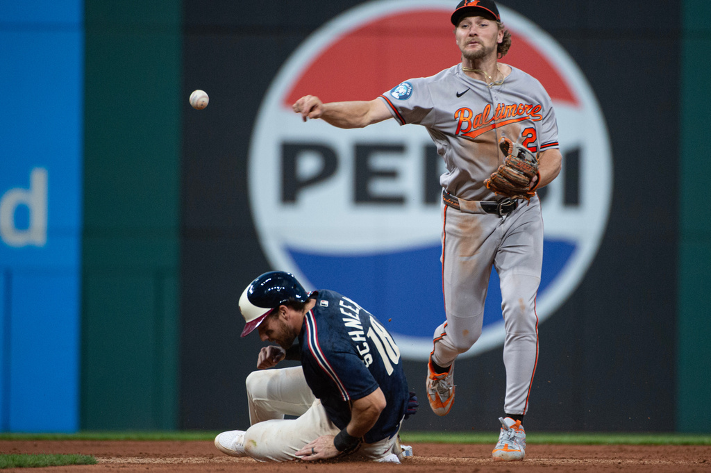 Baltimore Orioles' Gunnar Henderson, right, forces Cleveland Guardians' Daniel Schneemann, left, at second base but his throw to first was not in time for a double play during the sixth inning of a baseball game, Friday, April 17, 2026, in Cleveland. (AP Photo/Phil Long)