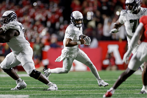 Oregon quarterback Dante Moore, center, runs with the ball during the first half of an NCAA college football game against Rutgers, Saturday, Oct. 18, 2025, in Piscataway, N.J. (AP Photo/Adam Hunger) Oregon quarterback Dante Moore, center, runs with the ball during the first half of an NCAA college football game against Rutgers, Saturday, Oct. 18, 2025, in Piscataway, N.J. (AP Photo/Adam Hunger)