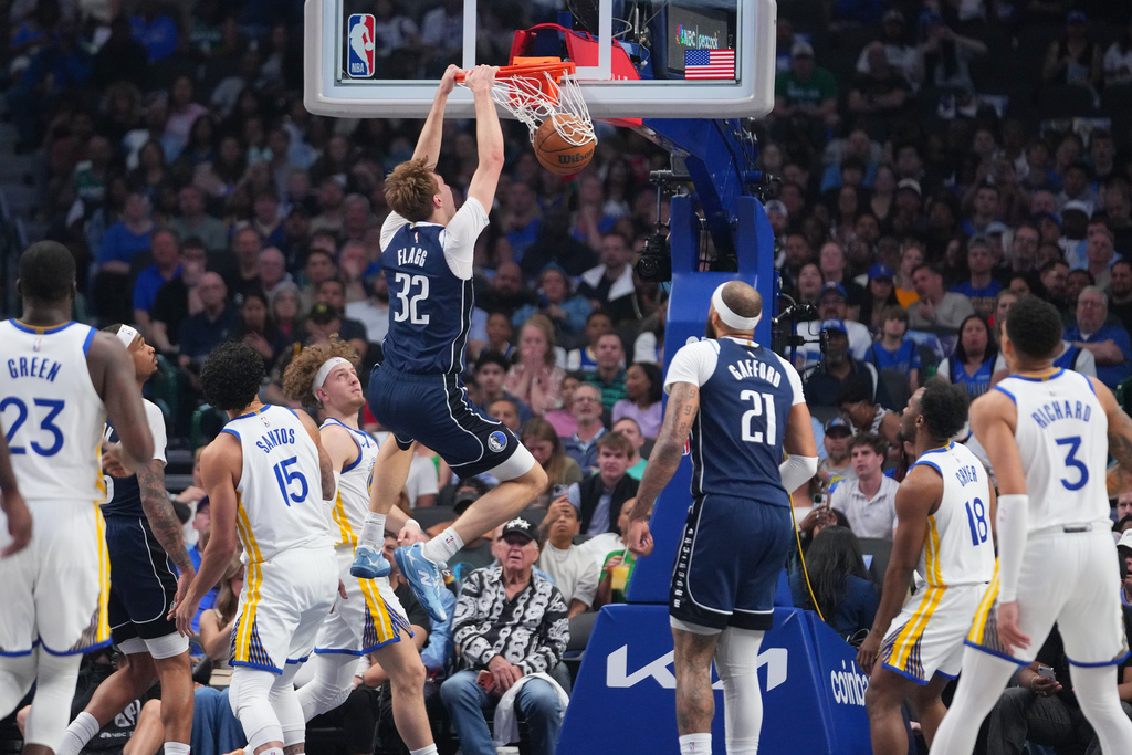 Dallas Mavericks forward Cooper Flagg (32) dunks on the Golden State Warriors during the first half of an NBA basketball game Monday, March 23, 2026, in Dallas. (AP Photo/Julio Cortez)