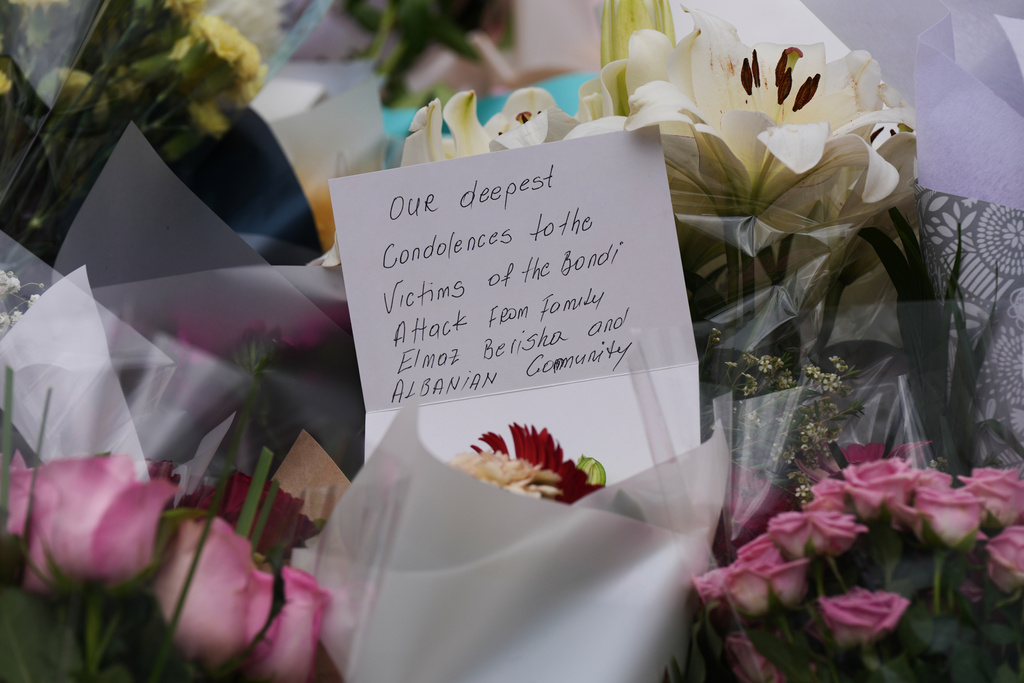 A condolence note left by a community member and attached to a flower at a tribute for shooting victims outside the Bondi Pavilion at Sydney's Bondi Beach, Monday, Dec. 15, 2025, a day after a shooting. (AP Photo/Mark Baker)
