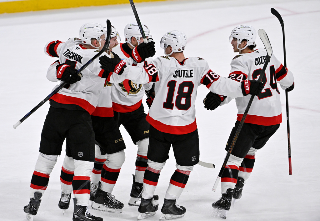 Ottawa Senators Jake Sanderson, second from left, celebrates after his tying goal against the Winnipeg Jets with teammates during the third period of an NHL hockey game in Winnipeg, Manitoba, Monday, Dec. 15, 2025. (Fred Greenslade/The Canadian Press via AP)