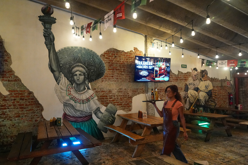 A mural that interprets the Statue of Liberty wearing a Mexican sombrero and traditional dress decorate the Texas-style restaurant El Pinche Gringo BBQ in Polanco, Mexico City, Tuesday, June 23, 2026. (AP Photo/Marco Ugarte)