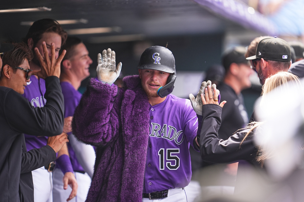 Colorado Rockies catcher Hunter Goodman, center, wears the home run coat as he is congratulated by teammates after hitting a solo home run off Houston Astros relief pitcher Enyel de Los Santos in the fourth inning of a baseball game Wednesday, April 8, 2026, in Denver. (AP Photo/David Zalubowski)