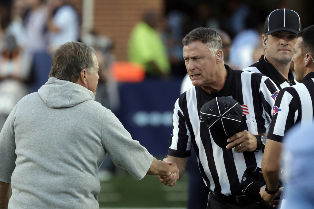 North Carolina head coach Bill Belichick, left, greets the officials before an NCAA college football game against TCU, Monday, Sept. 1, 2025, in Chapel Hill, N.C. (AP Photo/Chris Seward)