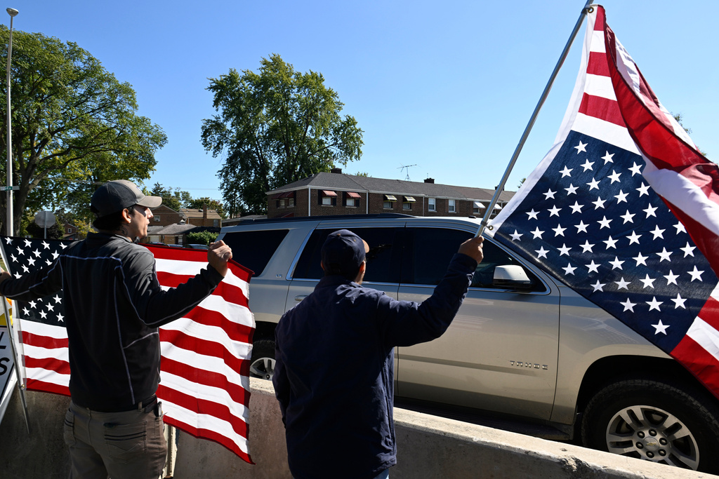 Protestors yell at Immigration and Customs Enforcement agents driving out of an immigration processing facility in Broadview, Ill., Thursday, Oct. 9, 2025. (AP Photo/Paul Beaty)