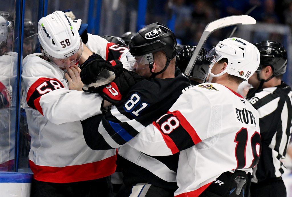 Ottawa Senators center Tim Stützle (18) grabs Tampa Bay Lightning defenseman Erik Cernak (81) as Cernak and defenseman Carter Yakemchuk (58) fight during the second period of an NHL hockey game Saturday, March 28, 2026, in Tampa, Fla. (AP Photo/Jason Behnken)