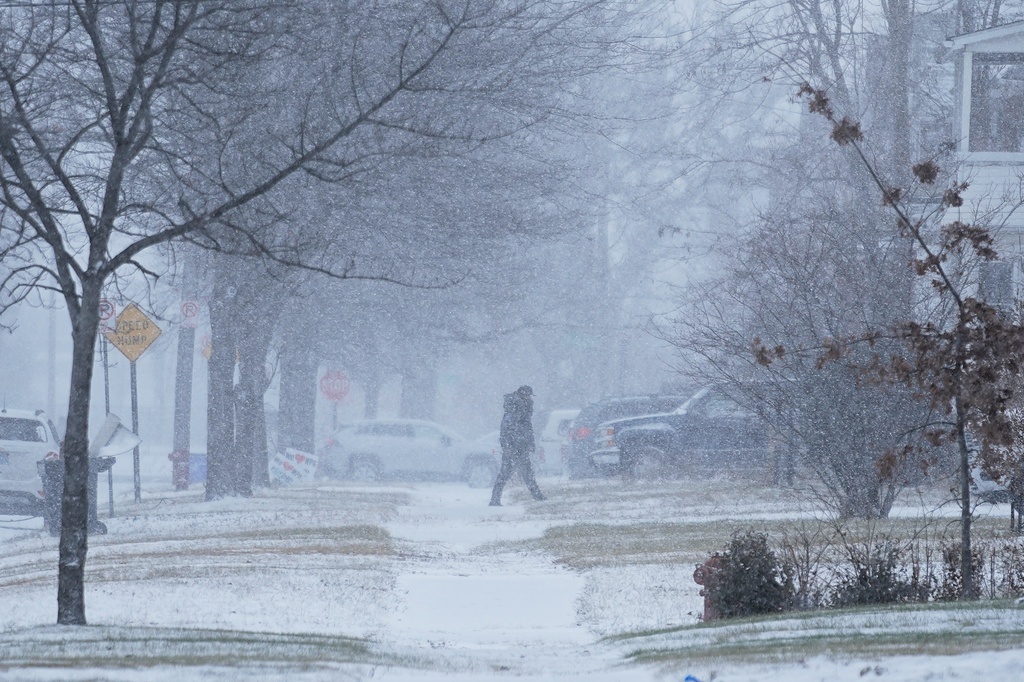 A person walks across the street after a winter storm system hit South East Michigan, Monday, Dec. 29, 2025, in Detroit. (AP Photo/Ryan Sun)