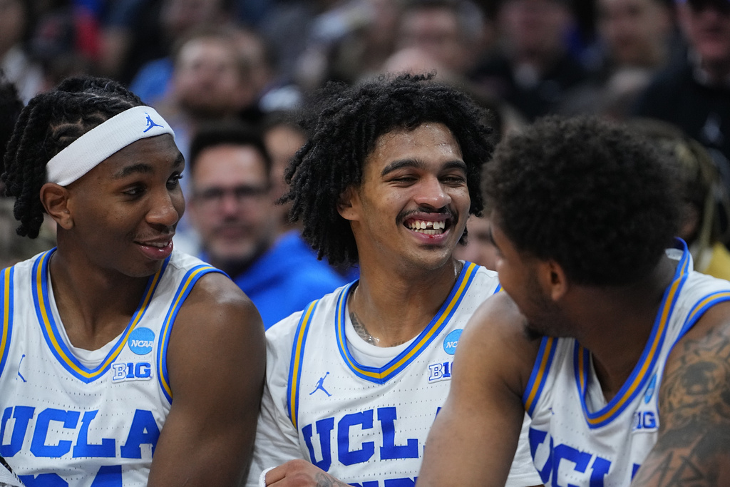 UCLA's Skyy Clark, center, smiles after chipping his tooth during the second half in the first round of the NCAA college basketball tournament against UCF, Friday, March 20, 2026, in Philadelphia. (AP Photo/Matt Rourke)