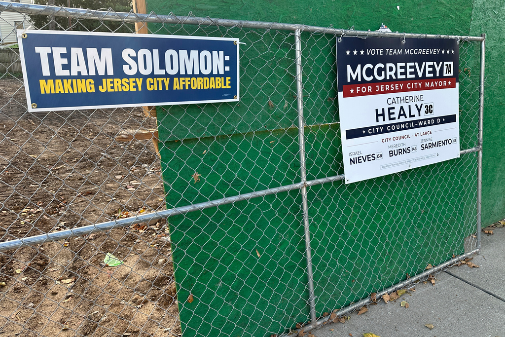 Campaign signs for Jersey City mayoral candidates are displayed in front of a vacant lot in the city's Heights neighborhood, Thursday, Oct. 23, 2025. (AP Photo/Robert Yoon)