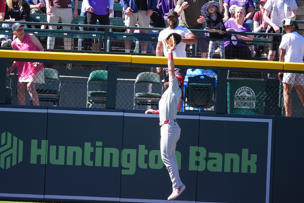 Philadelphia Phillies left fielder Brandon Marsh pulls in a fly ball off the bat of Colorado Rockies pinch-hitter Kyle Karros in the seventh inning of a baseball game Sunday, April 5, 2026, in Denver. (AP Photo/David Zalubowski)