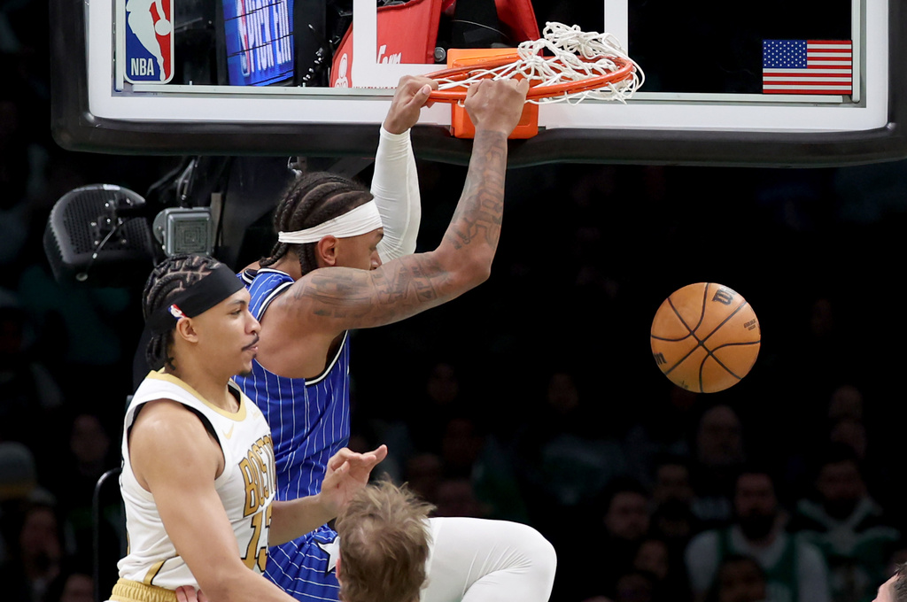 Orlando Magic forward Paolo Banchero, top right, dunks next to Boston Celtics forward Ron Harper Jr., top left, during the first half of an NBA basketball game, Sunday, April 12, 2026, in Boston. (AP Photo/Mark Stockwell)
