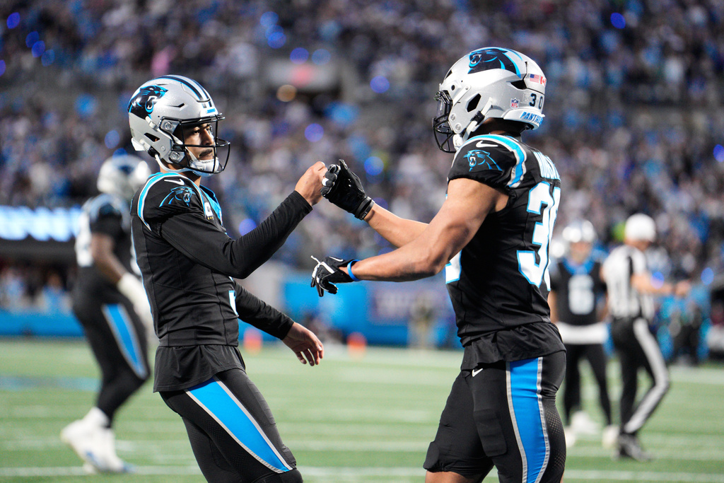 Carolina Panthers running back Chuba Hubbard, right, celebrates after scoring with quarterback Bryce Young during the first half of an NFL wild-card playoff football game against the Los Angeles Rams, Saturday, Jan. 10, 2026, in Charlotte, N.C. (AP Photo/Jacob Kupferman)