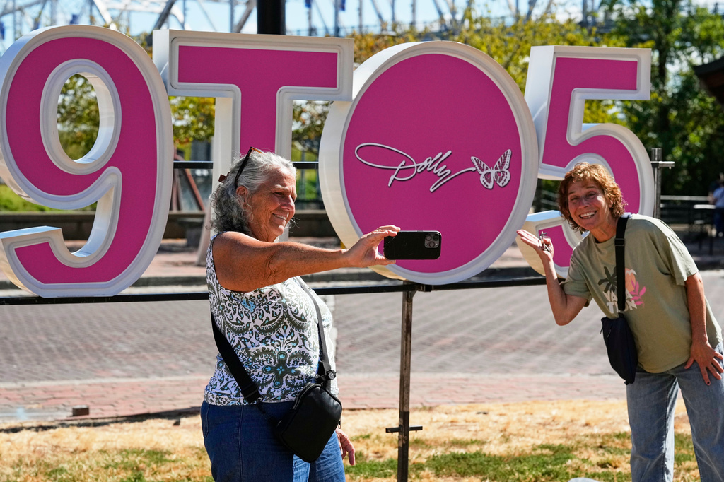 Wendy Delehanty, left, and Nancy Beaty of Jew Jersey pose with a sign during Dolly Parton Day honoring the late country music artist, Friday, Sept. 25, 2026, in Nashville, Tenn. (AP Photo/George Walker IV)