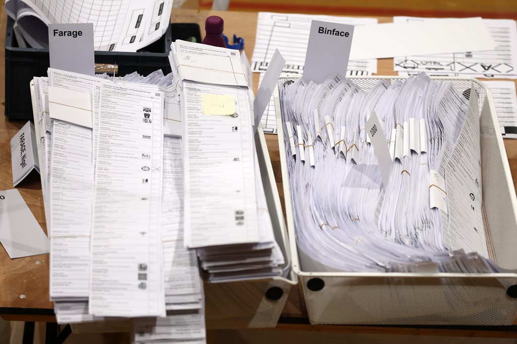 Ballot papers sorted for Farage and Binface are collected in boxes during the Clacton by-election count at the Leisure Centre in Clacton on Sea, Friday, Aug. 14, 2026.(AP Photo/Richard Pelham)