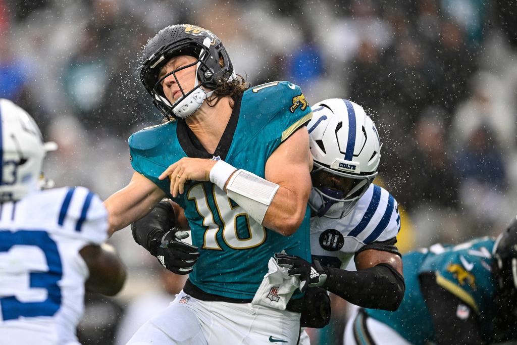 Jacksonville Jaguars quarterback Trevor Lawrence (16) is hit by Indianapolis Colts safety Nick Cross (20) as he throws a pass during the first half of an NFL football game, Sunday, Dec. 7, 2025, in Jacksonville, Fla. (AP Photo/Phelan M. Ebenhack)