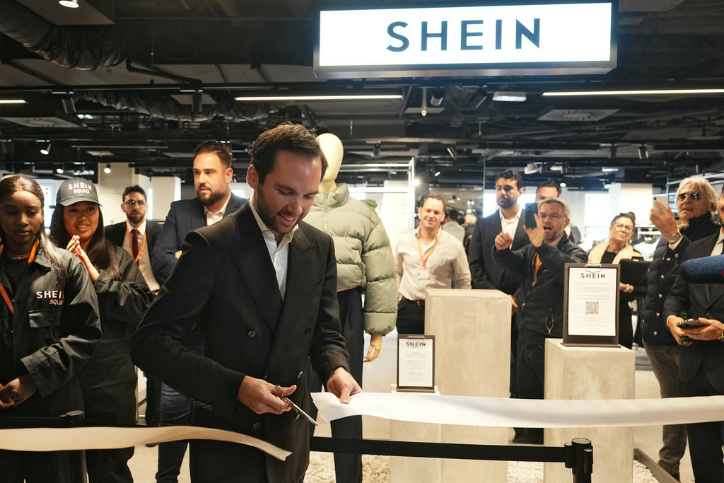 The director of the Bazar de l'Hotel de Ville (BHV) department store Karl-Stephane Cottendin cuts the ribbon at the opening Shein's first physical store in Paris, Wednesday, Nov. 5, 2025. ( Dimitar Dilkoff, Pool via AP)