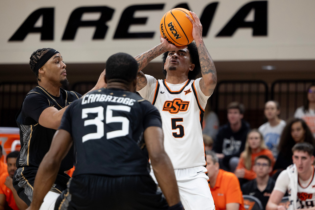 Oklahoma State guard Vyctorius Miller (5) shoots over Central Florida forward Devan Cambridge (35) and guard George Beale Jr. (3) in the second half of the NCAA college basketball game, Tuesday, Jan. 6, 2026 in Stillwater, Okla. (AP Photo/Mitch Alcala)