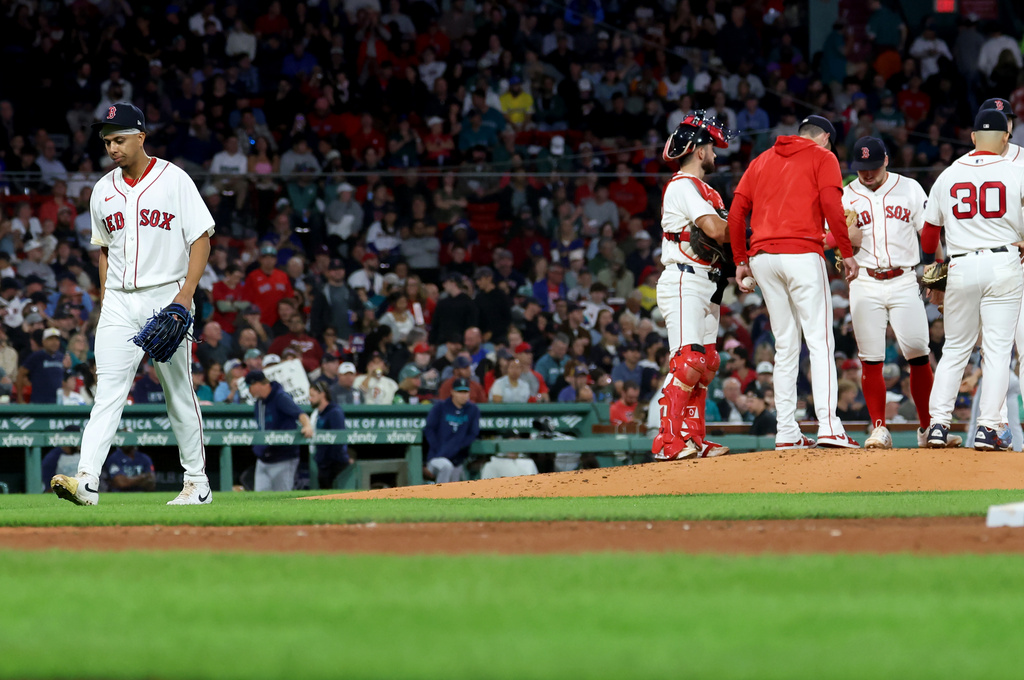 Boston Red Sox pitcher Jedixson Paez, left, is taken out of the game during the fourth inning of a baseball game against the Seattle Mariners, Tuesday, Sept. 1, 2026, in Boston. (AP Photo/Mark Stockwell)
