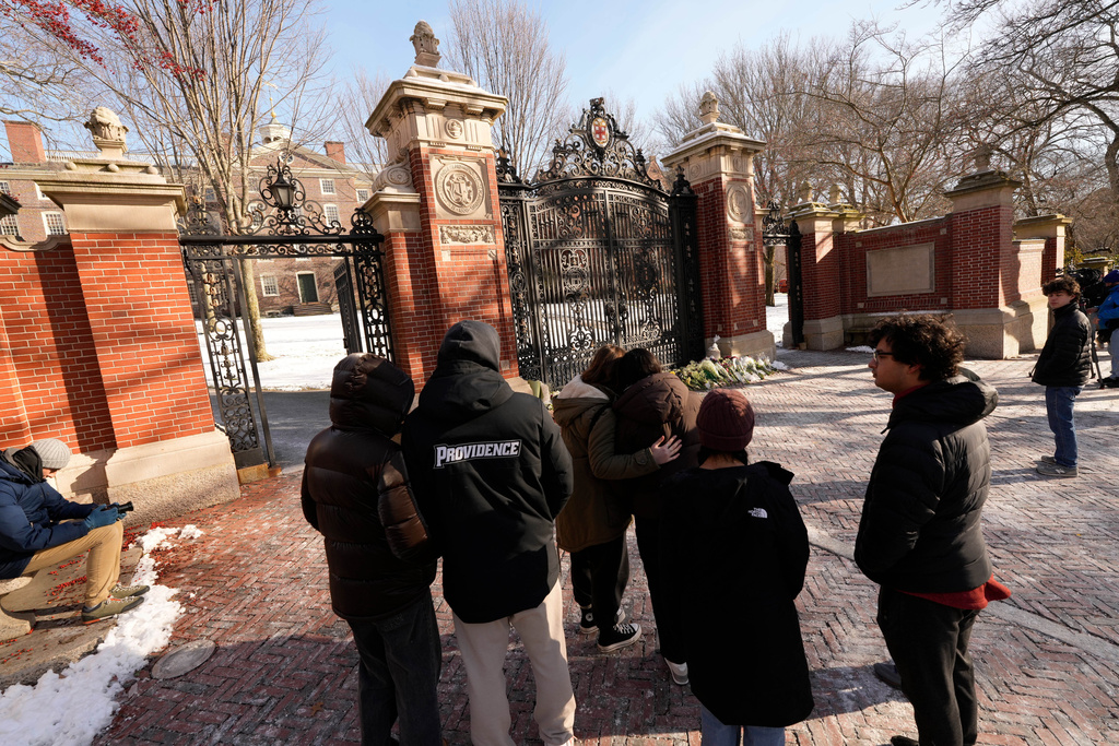 People gather at near makeshift memorial on the campus of Brown University, not far from the scene of the shooting, Monday, Dec. 15, 2025, in Providence, R.I. (AP Photo/Robert F. Bukaty)