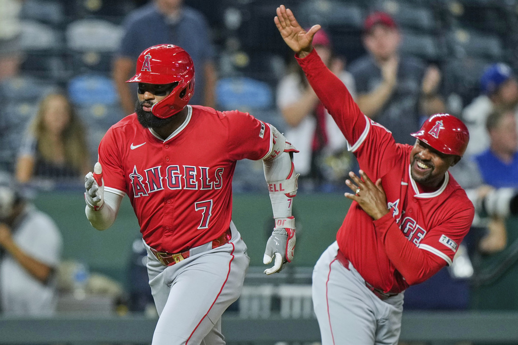 Los Angeles Angels' Jo Adell (7) celebrates with third base coach Bo Porter as he runs home after hitting a three-run home run during the sixth inning of a baseball game against the Kansas City Royals, Wednesday, Sept. 3, 2025, in Kansas City, Mo. (AP Photo/Charlie Riedel)