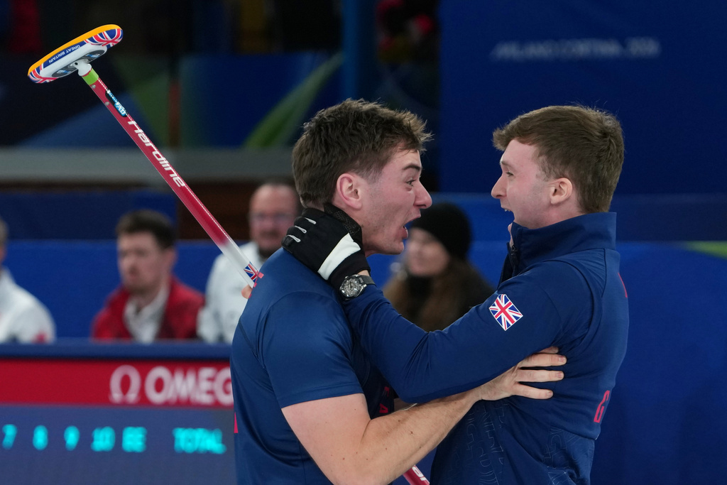 Britain's Grant Hardie and Bruce Mouat react after beating Switzerland in a men's curling semifinal match at the 2026 Winter Olympics, in Cortina d'Ampezzo, Italy, Thursday, Feb. 19, 2026. (AP Photo/Misper Apawu)