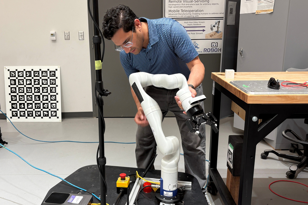 Nikhil Malhotra, co-founder of New Frontier Robotics, demonstrates his mobile manipulator robot arm in a lab at the University of Waterloo on July 8, 2026, in Waterloo, Ontario. (AP Photo/Kelvin Chan)
