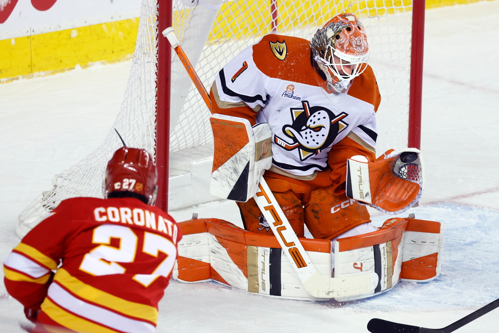 Anaheim Ducks goalie Lukas Dostal (1) makes a save against Calgary Flames' Matt Coronato (27) during first-period NHL hockey game action in Calgary, Alberta, Sunday, Jan. 25, 2026. (Larry MacDougal/The Canadian Press via AP)