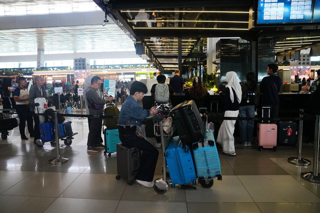 Travelers wait for their flights at Soekarno-Hatta International Airport in Tangerang, Indonesia, Sunday, Sept. 6, 2026. (AP Photo/Tatan Syuflana)