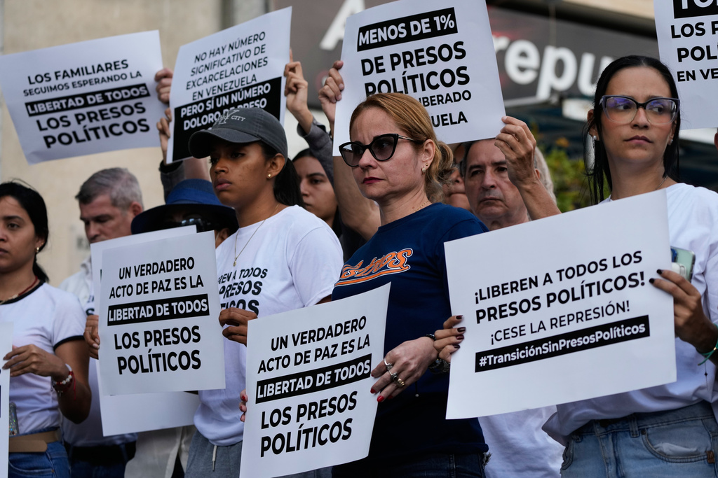 Relatives and friends of political prisoners hold banners calling for their loved ones to be set free outside El Helicoide, the headquarters of Venezuela's intelligence service and detention center, in Caracas, Venezuela, Friday, Jan. 9, 2026 after the government announced prisoners would be released.(AP Photo/Ariana Cubillos)